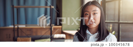 Young asian businesswoman standing at office and holding phone 100345678