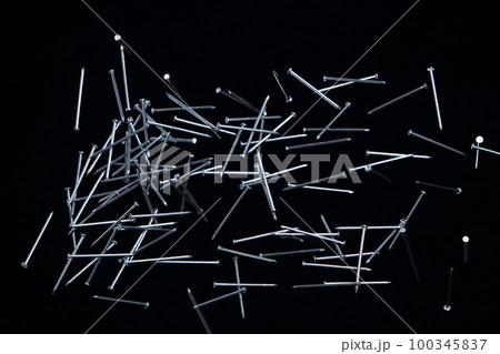 Long Nail fly floating in mid air. Many group screw nails short long metal fall as construction tools. Black background isolated. New Screwdriver Nail fall down unbox steel hardware work 100345837