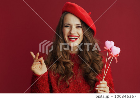 happy trendy female with long wavy hair and hearts on stick 100346367