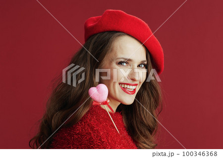 smiling trendy woman in red sweater and beret 100346368
