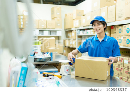倉庫で梱包作業をする若い男性 倉庫で梱包作業をする若い男性 100348337
