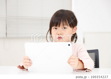 子供がタブレット端末を使って真剣に勉強またはゲームをするが不注意または目が疲れる 100354227