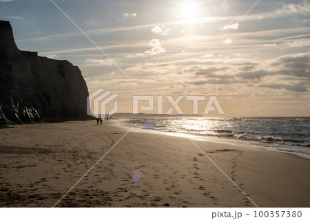 Amazing colorful sunset on a sandy beach at the sea under a sky painted with clouds and a golden sun Amazing colorful sunset on a sandy beach at the sea under a sky painted with clouds and a golden sun 100357380