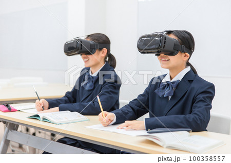 VRゴーグルをつけて勉強をする中学生・高校生の女の子(VR・AR・MR) 100358557