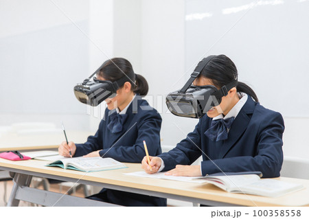 VRゴーグルをつけて勉強をする中学生・高校生の女の子(VR・AR・MR) 100358558