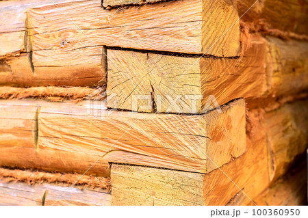 log wall, corner of a wooden house and a window 100360950