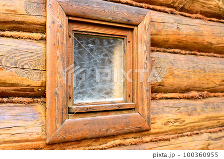 log wall, corner of a wooden house and a window 100360955