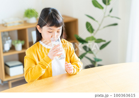 ミネラルウォーターを飲む小学生の女の子 ミネラルウォーターを飲む小学生の女の子 100363615