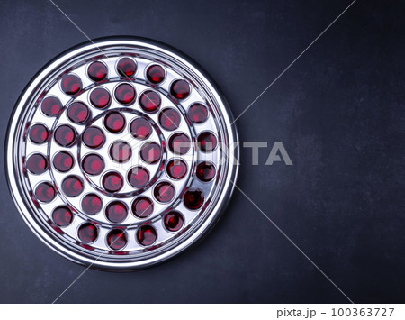 Communion glass cups with wine the symbol of Jesus Christ blood on black background Communion glass cups with wine the symbol of Jesus Christ blood on black background 100363727