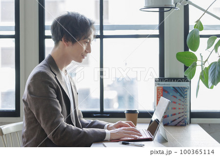 窓辺でパソコン作業をする男性 窓辺でパソコン作業をする男性 100365114