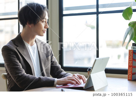 窓辺でパソコン作業をする男性 窓辺でパソコン作業をする男性 100365115