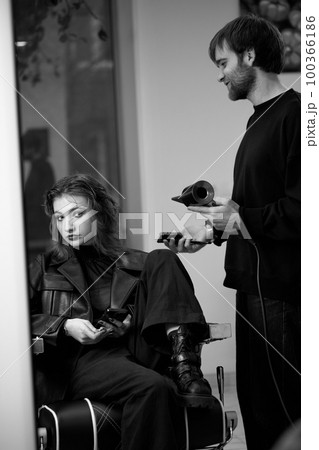 man hairdresser dries female hair with hairdryer after washing man hairdresser dries female hair with hairdryer after washing 100366186
