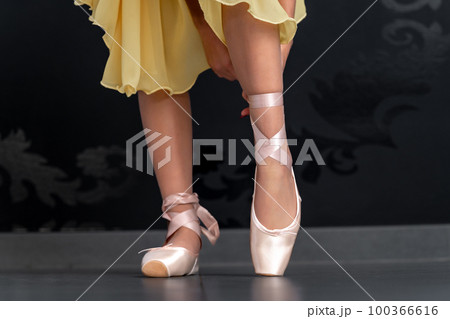 ballet shoes on the feet of a ballerina. close up ballet shoes on the feet of a ballerina. close up 100366616