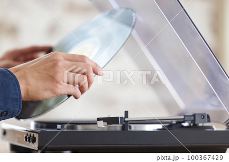 レコードをセットする男性の手元 100367429
