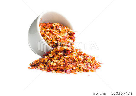 Dry chili pepper flakes in bowl. Crushed red peppers isolated on white background. Dry chili pepper flakes in bowl. Crushed red peppers isolated on white background. 100367472