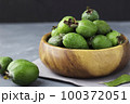 Green feijoa fruits in a wooden plate on a dark background. Tropical fruit feijoa. Set of ripe feijoa fruits. Copy space 100372051