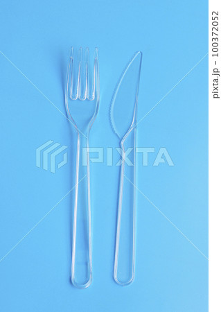 Plastic disposable tableware, cutlery. Fast food. Clean plastic fork and knive on blue background. 100372052