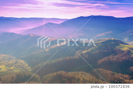 View of the tops of mountain ridge during sunset 100372836