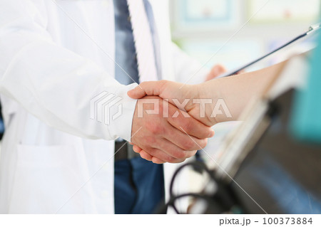 Doctor and patient shake hands in clinic closeup Doctor and patient shake hands in clinic closeup 100373884