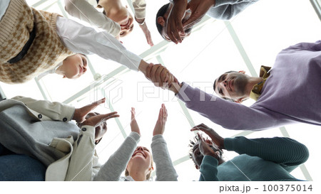 Closeup Business partners shaking hands, celebrating business success in modern office with high ceiling. Closeup Business partners shaking hands, celebrating business success in modern office with high ceiling. 100375014