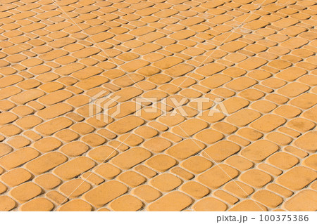 Light orange or yellow stone paving slabs floor tile urban texture background 100375386