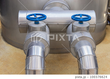Handwheel type blue metal valves and pipes, industrial equipment at wine factory, close up 100376624