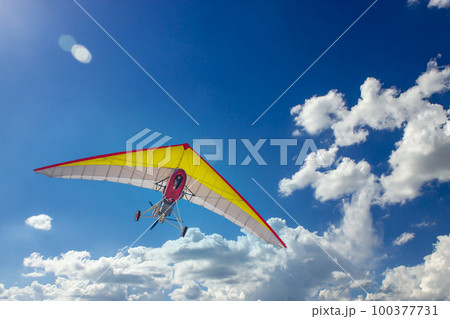 Motorized steerable paraglider flies in the sky, view from below Motorized steerable paraglider flies in the sky, view from below 100377731