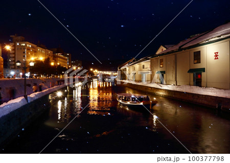 北海道北の大地（氷ずく極寒の冬の運河を町明かりが照らす。舟は光の川面を優雅に滑る。）小樽市・小樽運河 100377798