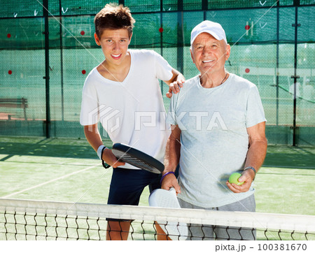 padel players of different generations posing on padel court 100381670