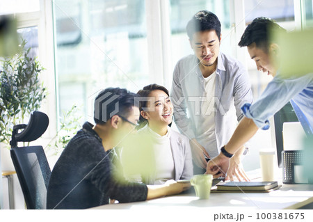 happy young asian corporate executives working together meeting in office discussing business happy young asian corporate executives working together meeting in office discussing business 100381675