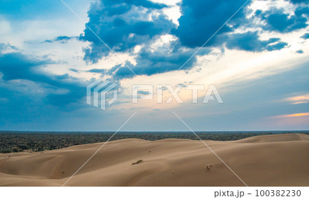 Bright blue cloudy sky over the yellow desert of Kyzylkum Kazakhstan. Rainy weather in the desert. Beautiful landscape of the desert of Central Asia 100382230