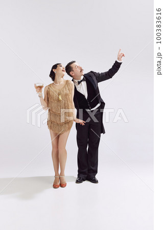Romantic date. Retro man and adorable woman in vintage evening festive outfits dancing retro ballroom dance. Concept of love and music, eras comparison 100383616