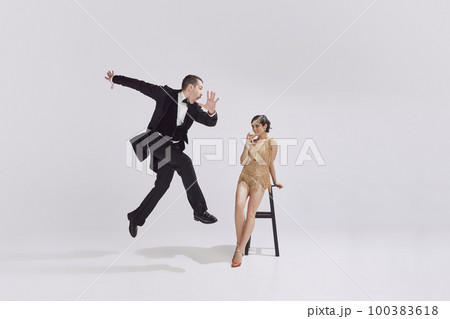 Retro man and adorable woman in vintage evening festive outfits dancing retro ballroom dance. Concept of ove and music, eras comparison 100383618