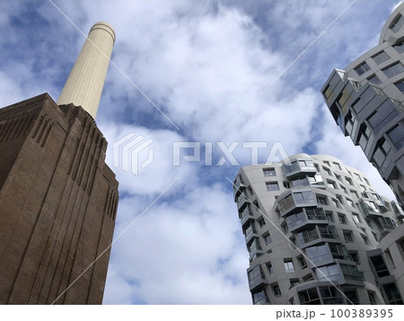 Battersea Power Station, London, UK. Old fashioned chimneys against modern new build architecture against one other, building city. 100389395