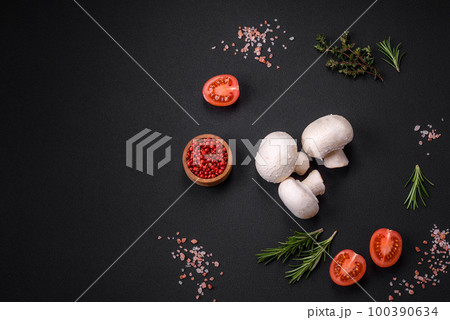 Fresh raw champignon mushrooms on a wooden cutting board with spices Fresh raw champignon mushrooms on a wooden cutting board with spices 100390634