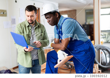 Male worker man is clarifying details of work from foreman Male worker man is clarifying details of work from foreman 100392012