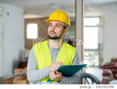 Builder making notes on indoor construction site Builder making notes on indoor construction site 100392496
