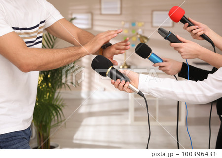 Man avoiding journalist's questions at interview indoors, closeup view Man avoiding journalist's questions at interview indoors, closeup view 100396431