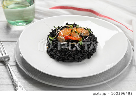 Delicious black risotto with seafood on white wooden table 100396493