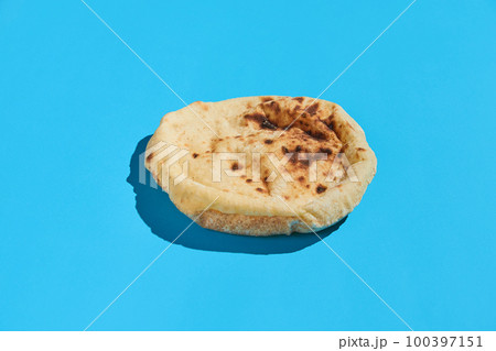 Egyptian bread Aish Baladi. Fresh bread lies on the blue table 100397151