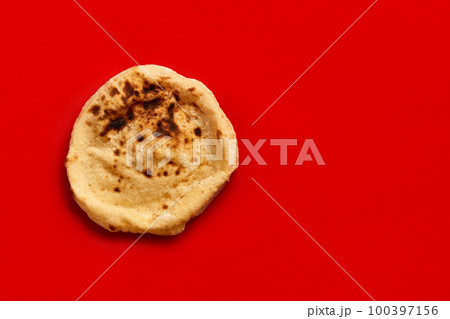 Egyptian bread Aish Baladi. Fresh bread lies on the red table Egyptian bread Aish Baladi. Fresh bread lies on the red table 100397156