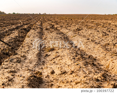 A plowed agricultural field against the cloudy skyline. 100397722