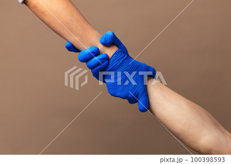 Handshake in a blue gloves, help concept. Personal hygiene during a pandemic Handshake in a blue gloves, help concept. Personal hygiene during a pandemic 100398593