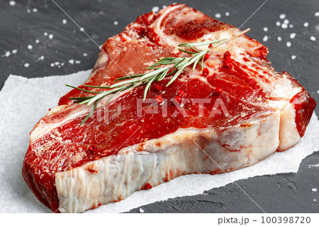 Raw fresh meat t-bone steak with spices on a dark background Raw fresh meat t-bone steak with spices on a dark background 100398720