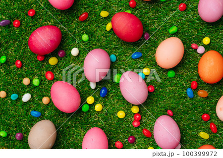 Colored eggs and vibrant candies on grass. Easter composition Colored eggs and vibrant candies on grass. Easter composition 100399972