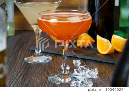 Two beautiful cocktails served on a wooden bar counter Two beautiful cocktails served on a wooden bar counter 100400204