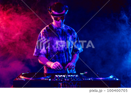 Club DJ playing music at party wearing sunglasses Club DJ playing music at party wearing sunglasses 100400705