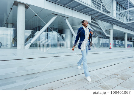 Attractive young african woman walking in the city 100401067