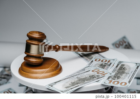 Brown wooden gavel and american dollars on gray background 100401115