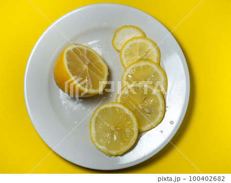 Lemon on a plate. Useful snack. Vitamin C concept Lemon on a plate. Useful snack. Vitamin C concept 100402682